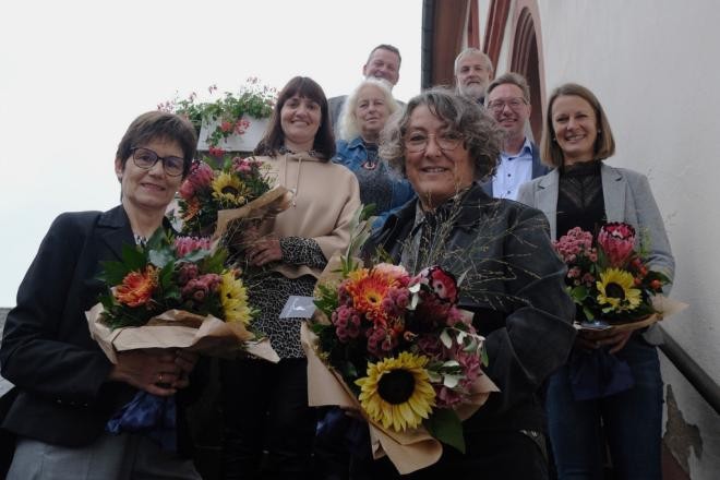 Anja Spitzer, Melanie Kappes, Silke Heiß und Rebekka Lack (von links; mit Sträußen) nehmen die Glückwünsche unter anderem von Oberbürgermeister Julian Stipp entgegen: Zusammen sind die Jubilarinnen seit 130 Jahren für die Stadt Mosbach im Dienst. ©Stadt Mosbach